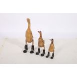 A SET OF THREE GRADUATED HARDWOOD FIGURES each modelled as a duck shown standing the larger 46cm,