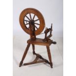 A HARDWOOD SPINNING WHEEL of typical form 111cm (h) x 50cm (w) x 55cm (d) together with a 19th