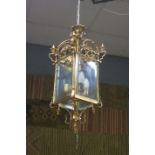 A GILT BRASS AND GLAZED FOUR LIGHT HALL LANTERN of square form with bevelled glass panels and