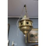 AN EASTERN BRASS LANTERN of dome form with pierced decoration raised on chain suspensions