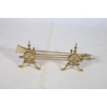 A SET OF THREE BRASS FIRE IRONS with urn handles together with a pair of fire dogs moulded in