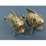 An Oriental silver metal pepper in the form of an articulated fish with green glass eyes plus one