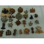 Twenty-five British Army regimental cap badges