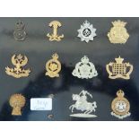 Twenty-five WWI / WWII British Army cap badges mounted on boards
