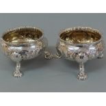 Pair of GIII chased silver salts with gadrooned borders, floral decoration to bodies, shell knees