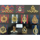 Twenty-two WWI / WWII British Army cap badges mounted on boards