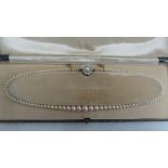 Early 20thC graduated pearl necklace with diamond clasp - length 18 ins.