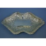 A Victorian chased silver bread dish of shaped oval form with floral, C scroll and shell decoration.