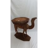 An Anglo-Indian carved teak occasional table modelled as a camel, circa 1900. The octagonal top