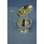 An Edwardian silver cream jug of baluster form with feather decoration to handle. Birmingham 1907. 8