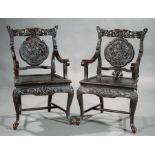 Pair of Chinese Carved and Ebonized Armchairs , late 19th/20th c., reticulated back rail, carved