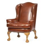 Georgian-Style Wingchair, mid-20th c., arched back, outswept arms, foliate scrolled knee, carved