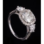 18 kt. White Gold and Diamond Ring , center prong set round brilliant cut diamond within pave