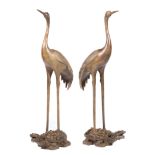 Pair of Chinese Bronze Figural Groups , cast in mirror image as cranes standing on the backs of
