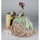 An Italian ceramic figure of a lady playing the piano by Giovanni Girardi, 25cm high