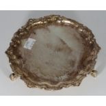 A small circular silver salver by Adie Brothers Ltd, the edges with carved decoration, raised on