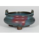 A Jun ware twin handled shallow bowl in blue and pink glaze, raised on tripod legs, approx. 14cm