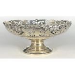 A circular silver fruit bowl, with pierced and foliate embossed rim, raised on circular spreading