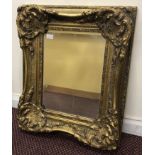 A rectangular bevelled mirror in ornate giltwood frame, 60 x 40cm, together with a large