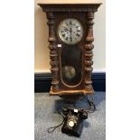 A stained pine Vienna style wall clock with carved pilasters, silvered dial and roman numerals,