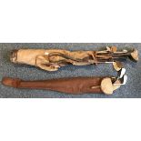 A quantity of vintage golf clubs including some hickory handled, in canvas and leather golf bag