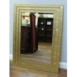 A modern rectangular bevelled mirror in stepped and gilded frame, 91 x 122cm