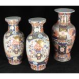 A three-piece 20th century Chinese porcelain matched garniture of vases in the 'Imari' style, the