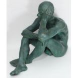 A verdigris bronzed pottery nude figure of a seated man, cross-legged with head resting in left