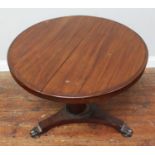 A circular mahogany tilt-top table, raised on octagonal support to tripod base with claw feet,