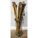 A cast iron and brass circular walking stick / umbrella stand with circular disc supported by