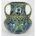 A Moorcroft pottery 'Cornflower' pattern twin handled vase, painted in shades of green and blue,