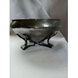 An Oliver Baker style tudric pewter bowl, the entirety with planished decoration, raised on three