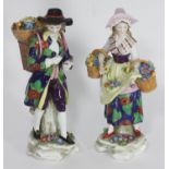 A pair of 19th century Continental porcelain figures of a pastoral couple carrying baskets of