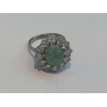 18ct white gold, jade and diamond cluster ring, centrally claw-set an oval cabochon cut jade