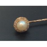An antique yellow gold, pearl and diamond stock pin, centrally-set a natural pearl (flattened