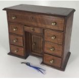 An early 20th century inlaid mahogany and oak lined miniature kneehole desk possibly an apprentice