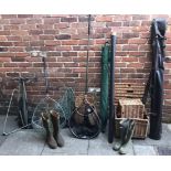 A quantity of fishing equipment including three various wicker baskets, various reels, nets, wellies