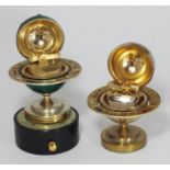 Two assorted table lighters, both modelled as globes with decorative Zodiac symbols, one a musical