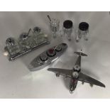 Two assorted chromium plated cruet sets, one modelled as an aeroplane, the other as a boat, each