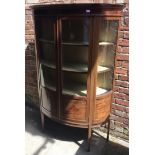 An inlaid mahogany Edwardian bow-front glazed display cabinet, the pair of doors enclosing shelved