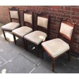 A set of four Edwardian stained walnut standard chairs, with carved top rails and floral, cream