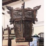 An Oriental intricately carved wooden hanging bird cage, with dragon finials, lattice sides with