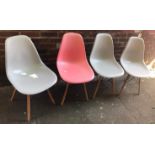 A set of four modern dining chairs in pink and grey, constructed from wood and plastic, based on the