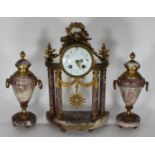 A 19th century French pink marble and gilded three piece garniture clock, flaming torch and laurel