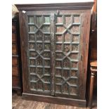 An Indian hardwood two-door store cupboard, 18th century lattice carved distressed doors with iron