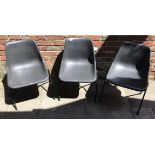 Three Robin Day for Hille black stacking chairs with labels underneath (3)