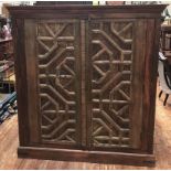 An Indian hardwood two-door store cupboard, 18th century lattice carved doors with iron ring pulls