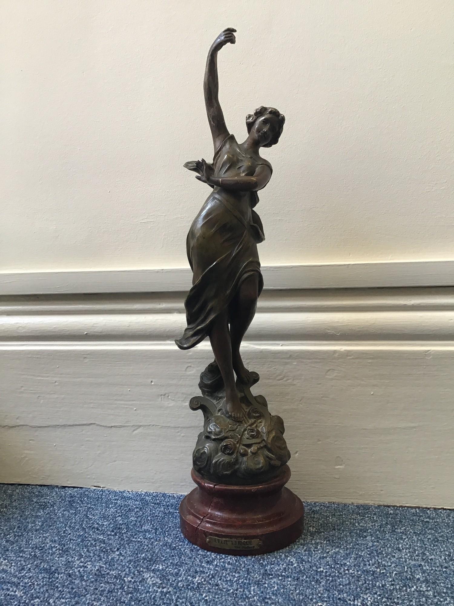 A spelter figure of a lady dancing entitled 'Eveil Lyrique Par Ruffony', raised on turned wooden