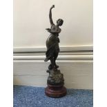 A spelter figure of a lady dancing entitled 'Eveil Lyrique Par Ruffony', raised on turned wooden