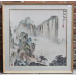 A Chinese silk embroidered panel depicting a mountainous landscape, with character marks and